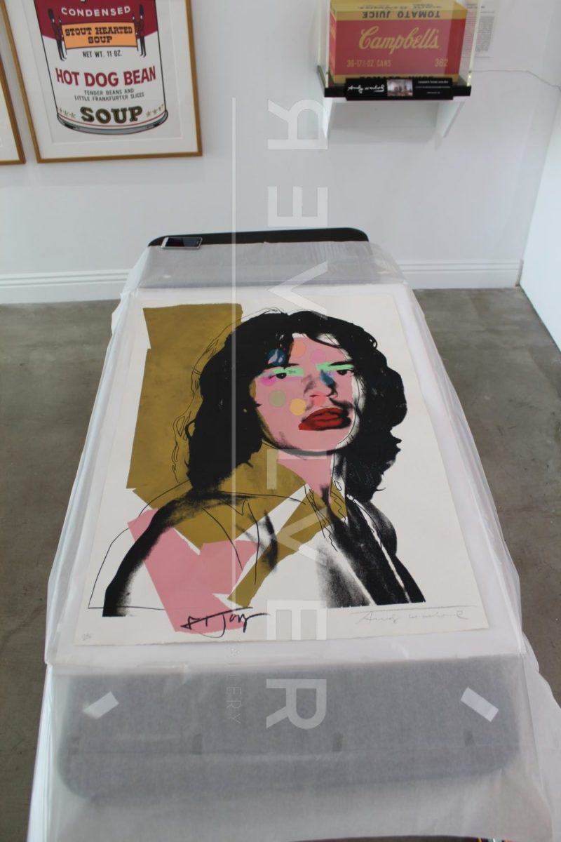 Andy Warhol Mick Jagger 143 screenprint out of frame laying on a table.