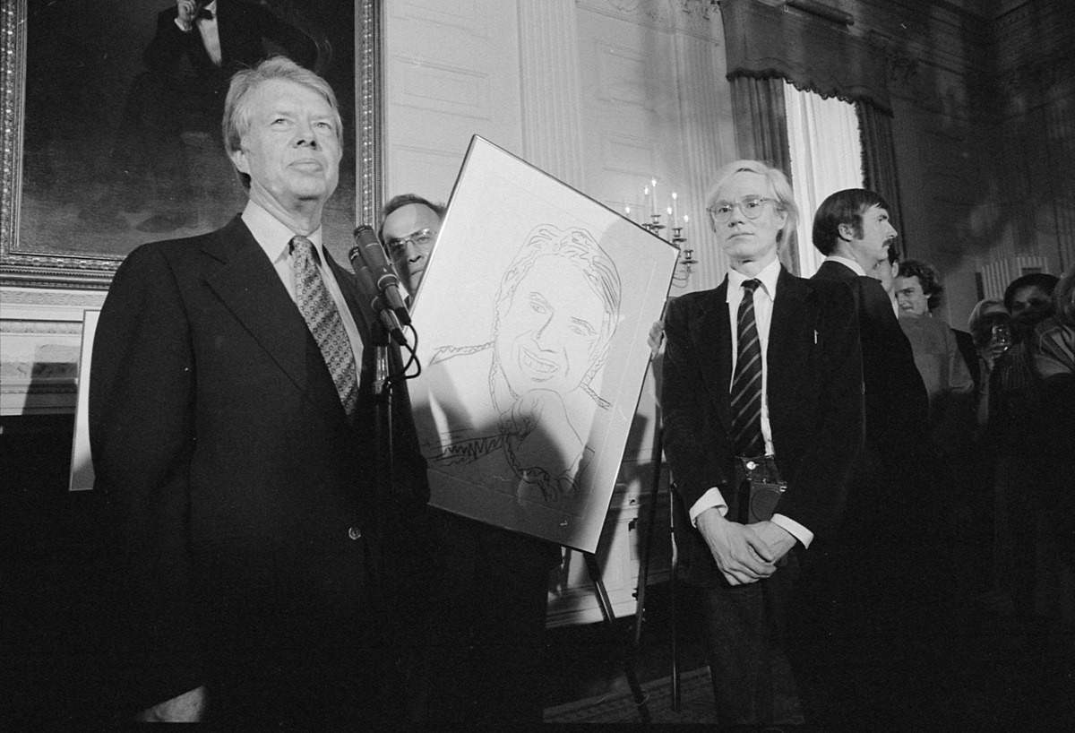 Warhol standing with his Jimmy Carter III 152 screenprint.