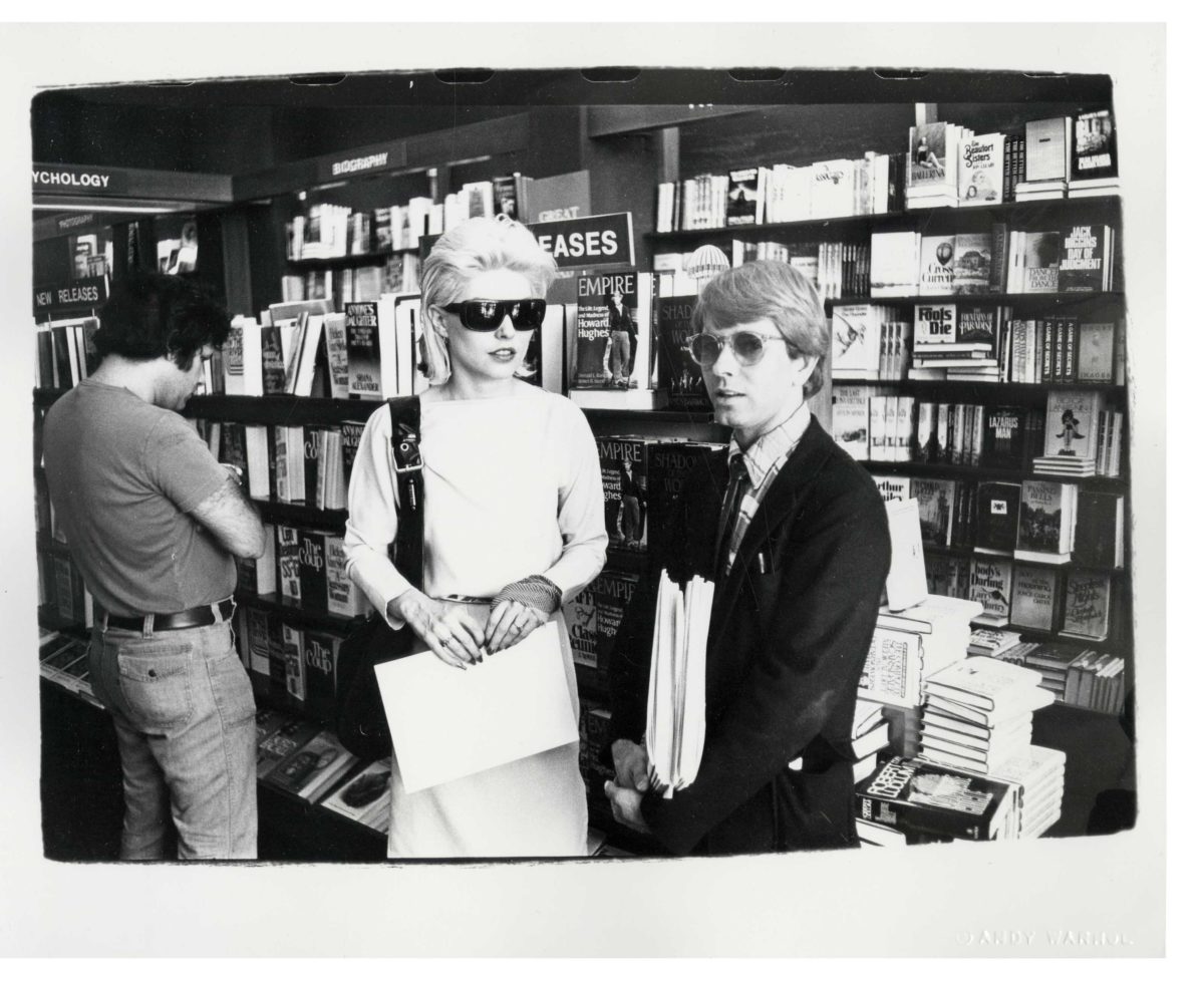 Rupert Smith and Debbie Harry standing in a magazine store.