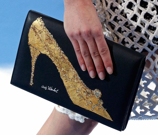 A model holds a Dior purse embued with one of Andy Warhol's Shoe drawings.