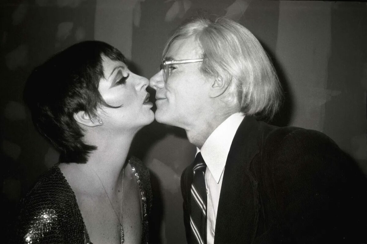 Liza Minnelli and Andy Warhol pretending to kiss.